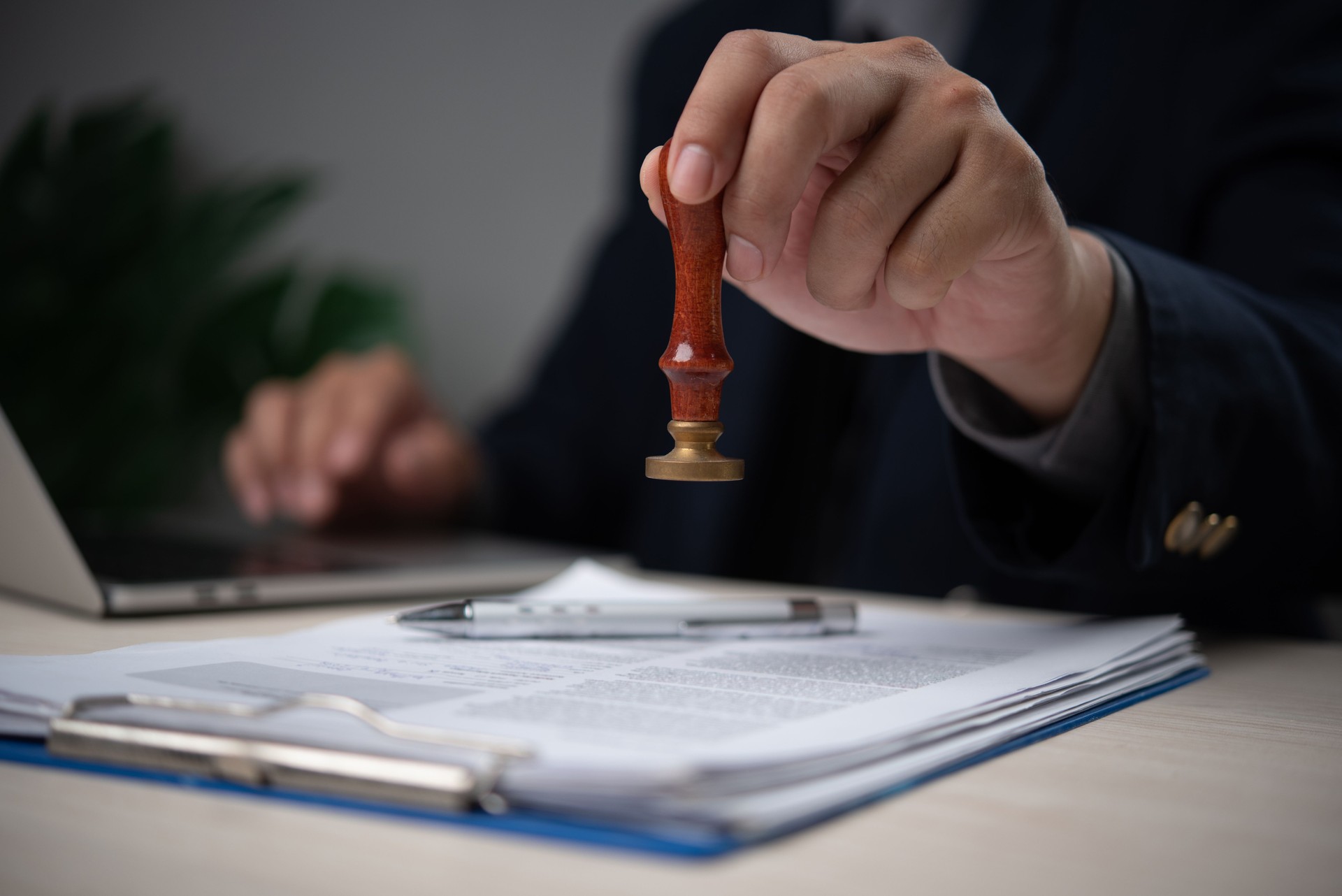 Confident Businessman Stamping Official Document in Modern Office Legal Approval Process